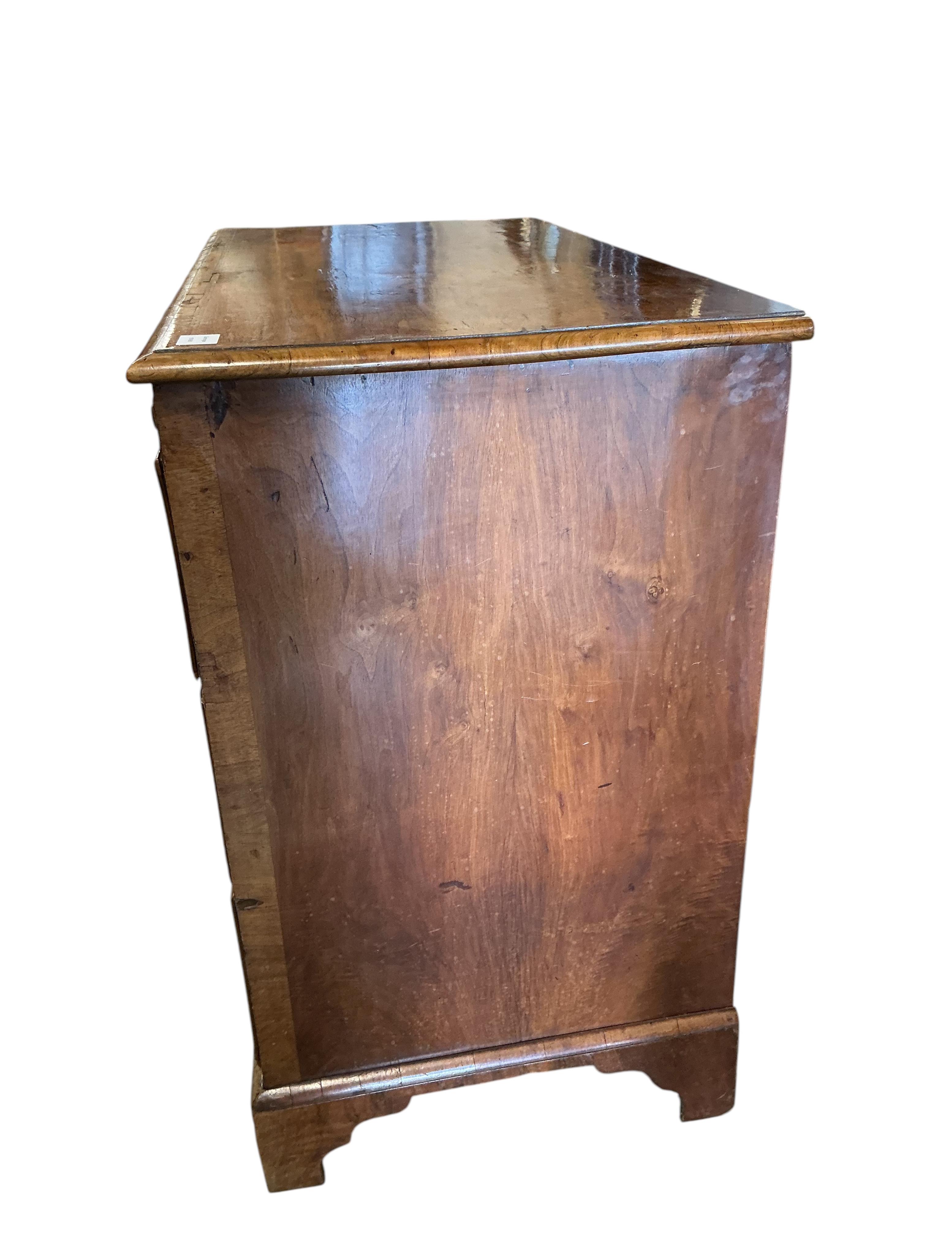A mid 18th century feather banded walnut concave starburst walnut chest of three drawers, with brushing slide, width 108cm, depth 54cm, height 92cm